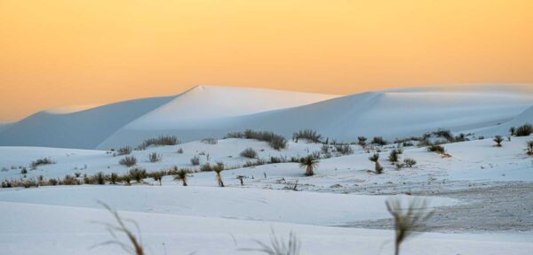 a snowy landscape with mountains in the distance