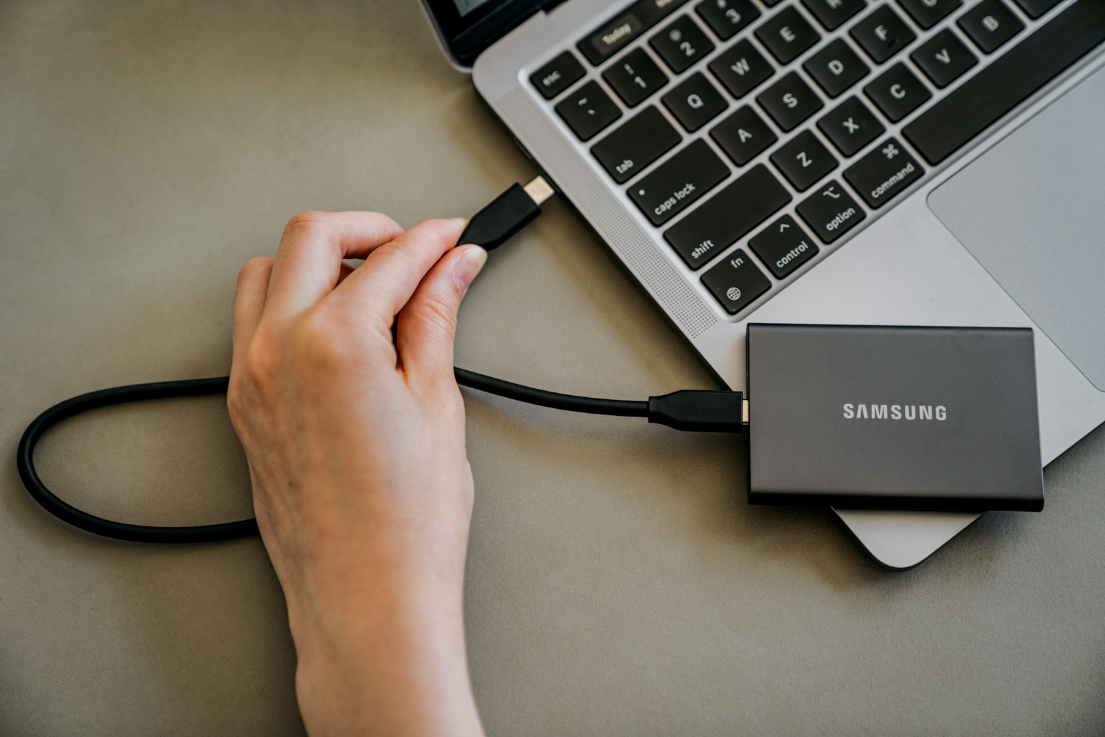 A person is plugging a charger into a laptop