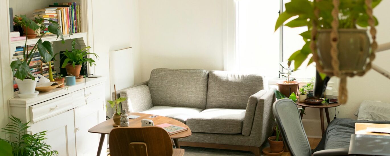 gray fabric loveseat near brown wooden table