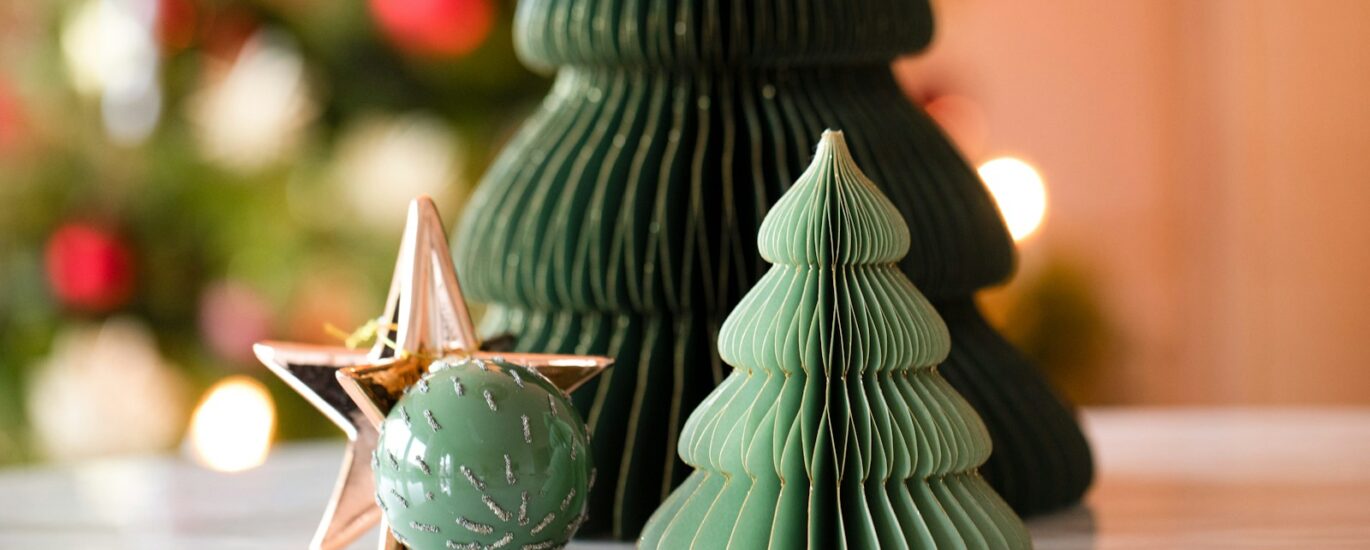 a small green christmas tree next to a green ornament