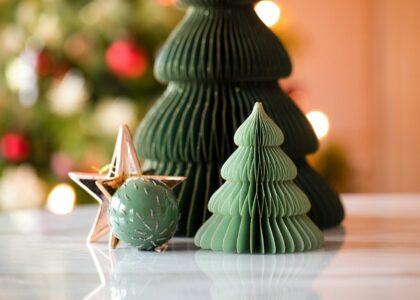 a small green christmas tree next to a green ornament