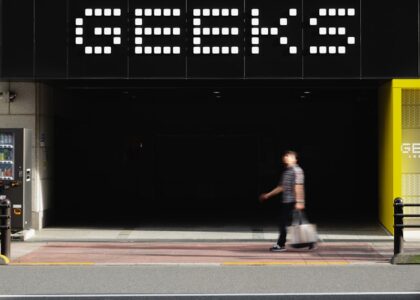 A man walking down a street next to a tall building